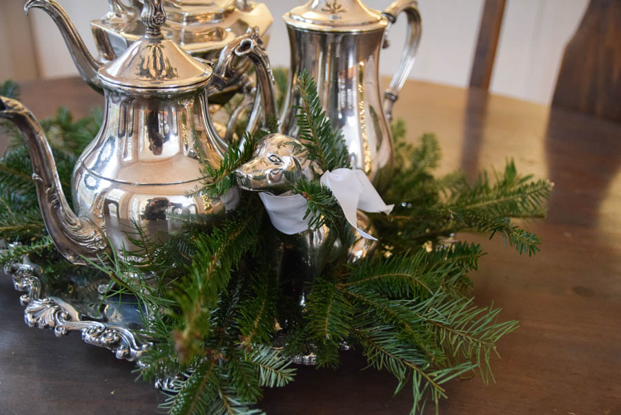 Table centerpiece with silver tea servers and dog