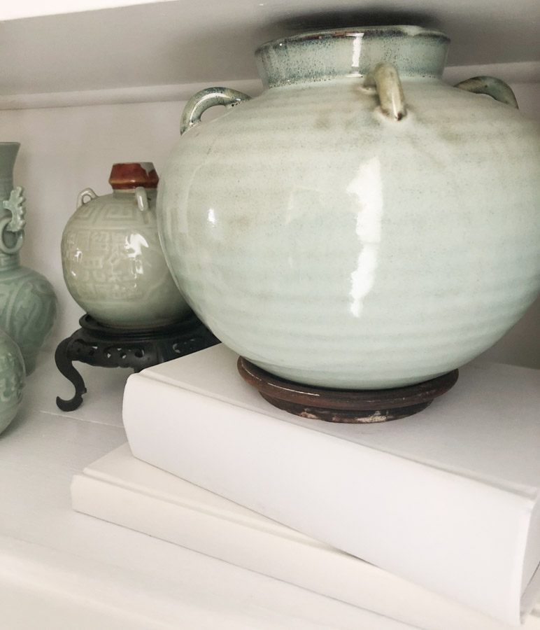 Green Asian Vase on top of white book display